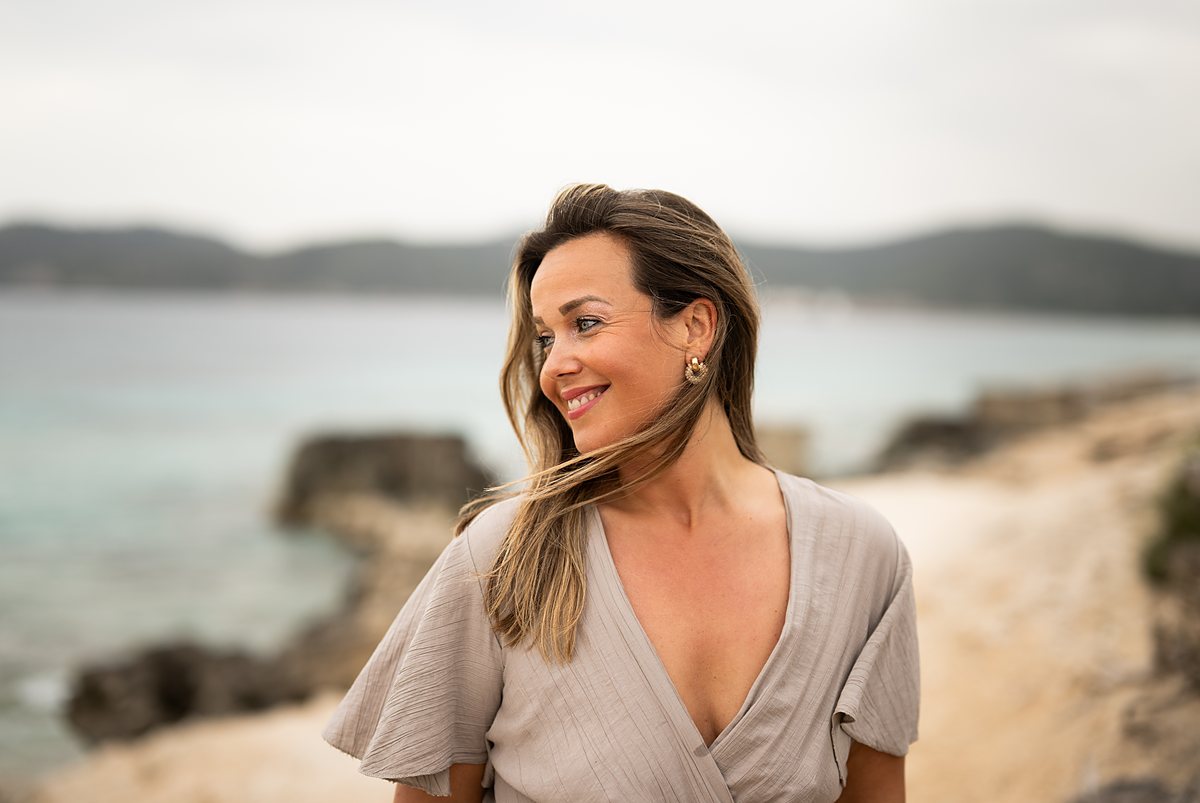 Lisette, traumacoach bij Anima Domus, aan de kust in zacht ochtendlicht.